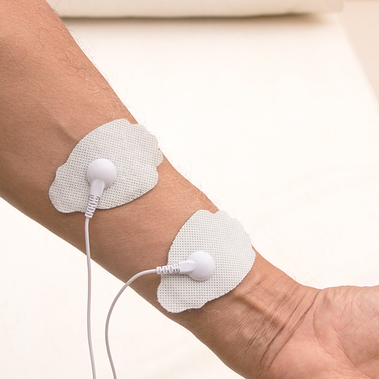 Tens unit pads on forearm